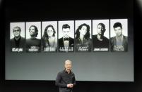 Apple Inc CEO Tim Cook talks about the iTunes Festival with some of the artists expected in the background during Apple Inc's media event in Cupertino, California September 10, 2013. REUTERS/Stephen Lam