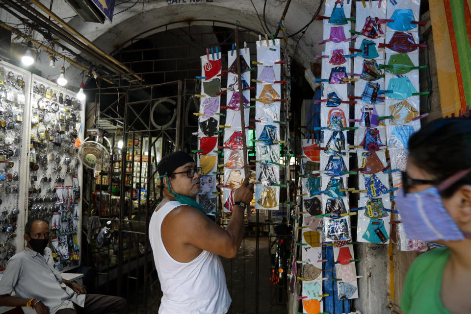 A vendor rearranges a display of face mask during relaxation hours of a lockdown to check the spread of the coronavirus in Kolkata, India, Monday, June 14, 2021. (AP Photo/Bikas Das)