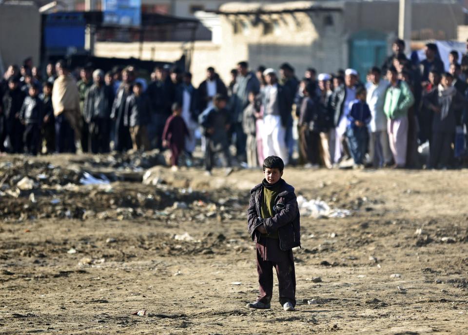 An Afghan child looks towards the site of a suicide bombing that struck near a NATO convoy in the Afghan capital Kabul, Afghanistan, Monday, Feb. 10, 2014. Taliban-affiliated militants have stepped up attacks in the final year of the international coalition’s 13-year combat mission in Afghanistan, seeking to shake confidence in the Kabul government’s ability to keep order after they assumed full security responsibility last year. (AP Photo/Massoud Hossaini)