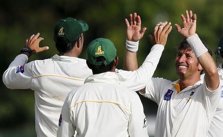 Pakistan's Yasir Shah (R) celebrates with his teammates after taking the wicket of Sri Lanka's Tharindu Kaushal (not pictured) during the second day of their second test cricket match against Pakistan in Colombo June 26, 2015. REUTERS/Dinuka Liyanawatte