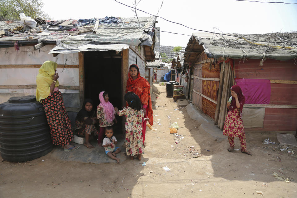 Rohingya refugees stand outside their makeshift camp on the outskirts of Jammu, India, Sunday, March 7, 2021. Authorities in Indian-controlled Kashmir have sent at least 168 Rohingya refugees to a holding center in a process which they say is to deport thousands of the refugees living in the region.(AP Photo/Channi Anand)