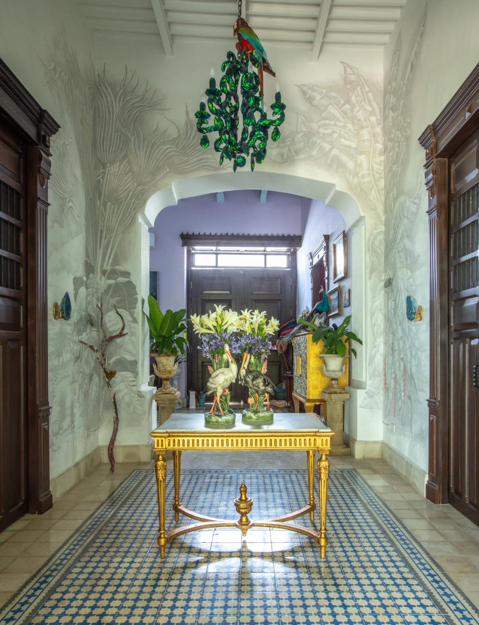 In the entry foyer, Skouras commissioned local artisan Miguel Rivero to paint a grisaille-style flora pattern on the walls. One of her light fixtures hangs above a 19th-century French table and English majolica vases.