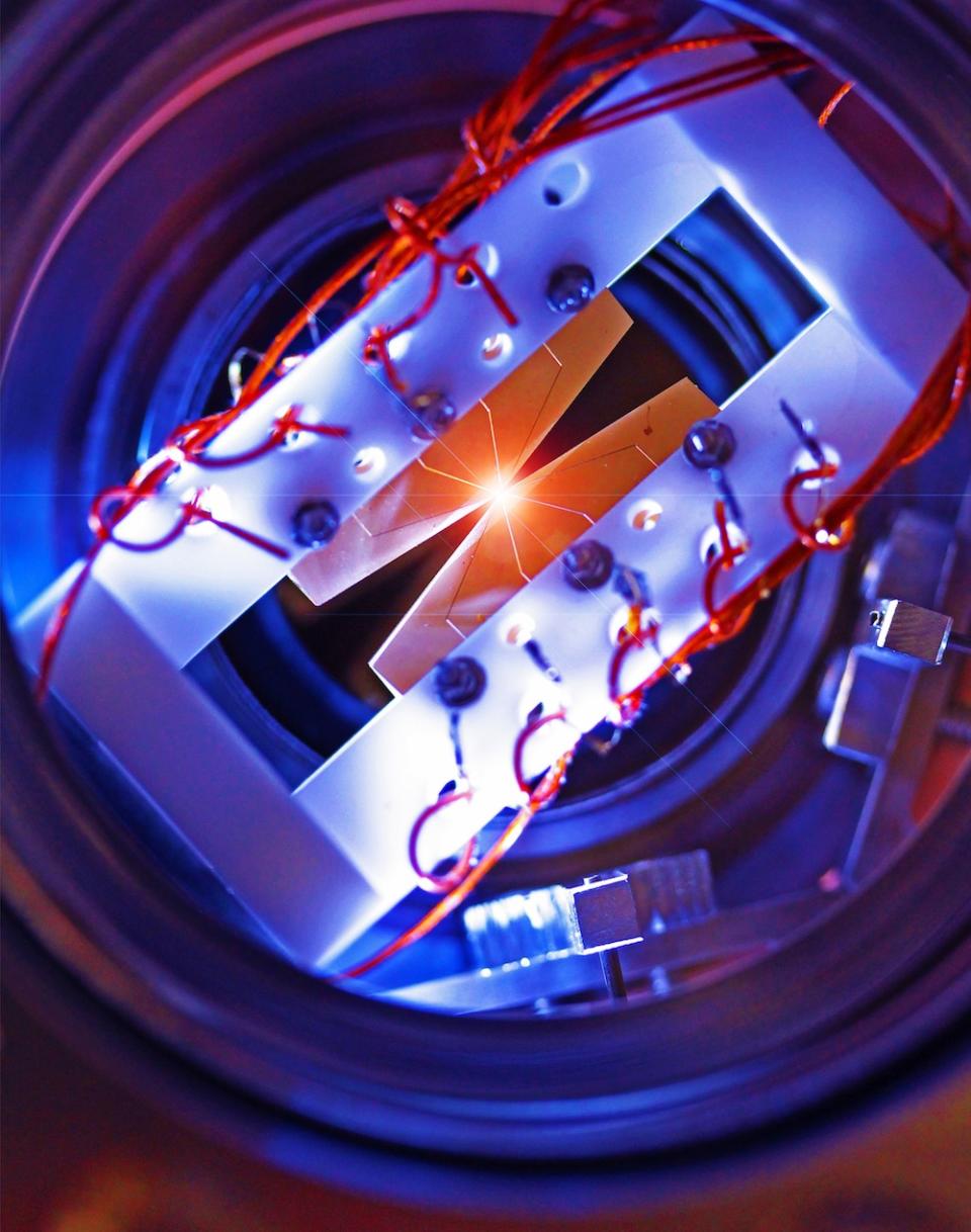 An ion trap with four segmented blade electrodes used to trap a linear chain of atomic ions for quantum information processing.