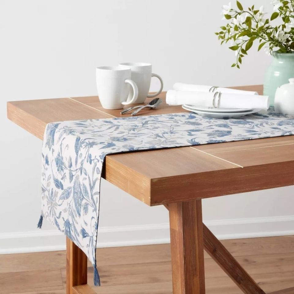 Wooden dining table with a floral table runner
