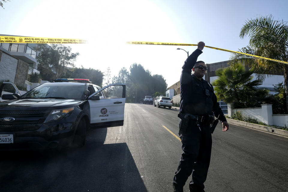 A police officer guards outside a Hollywood Hills home where a fatal shooting occurred on Wednesday, Feb. 19, 2020, in Los Angeles. (AP Photo/Ringo H.W. Chiu)