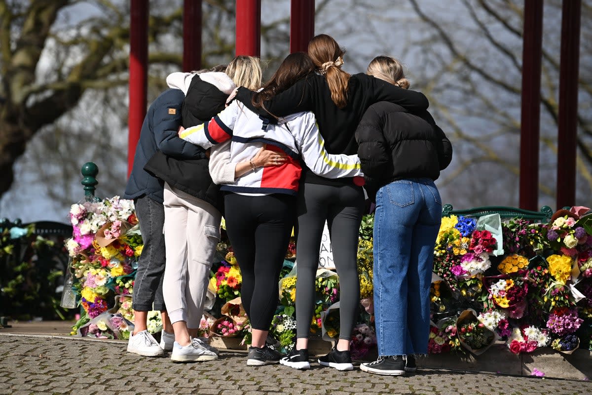 Tributes paid to Sarah Everard at Clapham Common vigil: A group of women hug as they stand in front of tributes for Sarah Everard (Getty Images)