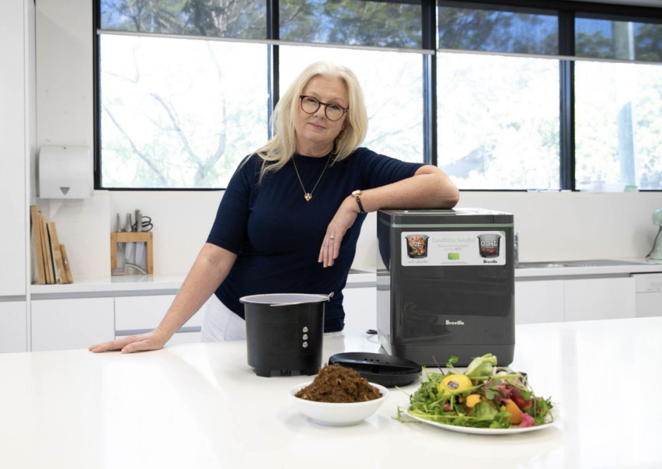 Woman stands in kitchen with fruit and vegetable scraps, Breville FoodCycler and eco-chips. 