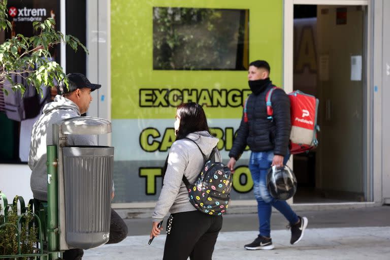 Un arbolito y una casa de cambio, la expresión de las dos formas de comprar y vender dólares en la city porteña