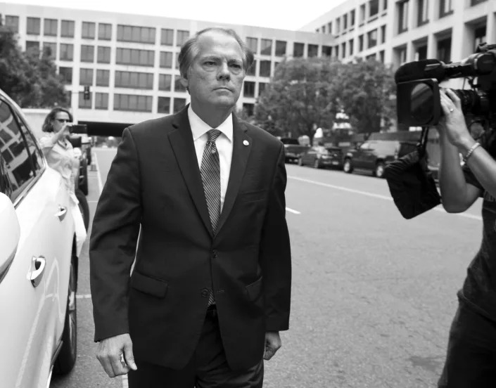James Wolfe, being filmed by a camera operator, leaves the federal courthouse in Washington.