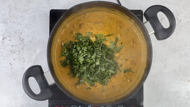 Adding cilantro to the lentil curry