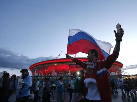 Soccer Football - World Cup - Group A - Russia vs Egypt - Saint Petersburg Stadium, Saint Petersburg, Russia June 19, 2018 A Russian fan waves a national flag after the match. REUTERS/Anton Vaganov