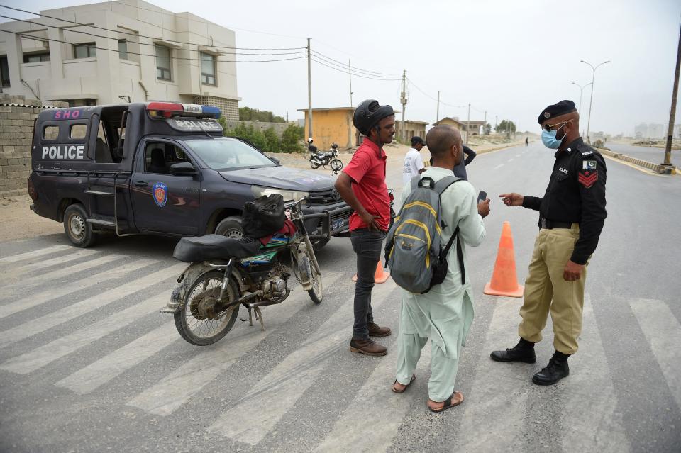 Police stop motorcyclists along a closed coastal road in Karachi, Pakistan, June 13, 2023, as Cyclone Biparjoy makes its way across the Arabian Sea toward the coastlines of Pakistan and India. / Credit: RIZWAN TABASSUM/AFP/Getty