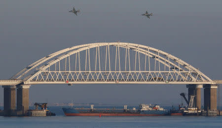 FILE PHOTO: Russian jet fighters fly over a bridge connecting the Russian mainland with the Crimean Peninsula with a cargo ship beneath it after three Ukrainian navy vessels were stopped by Russia from entering the Sea of Azov via the Kerch Strait in the Black Sea, Crimea November 25, 2018. REUTERS/Pavel Rebrov/File Photo