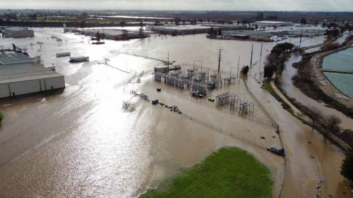 An electrical substation and other industrial buildings along Cooper Avenue in west Merced were submerged by flood waters when Black Rascal Creek, visible at right, breached its banks during a rainstorm on Jan. 10, 2023.