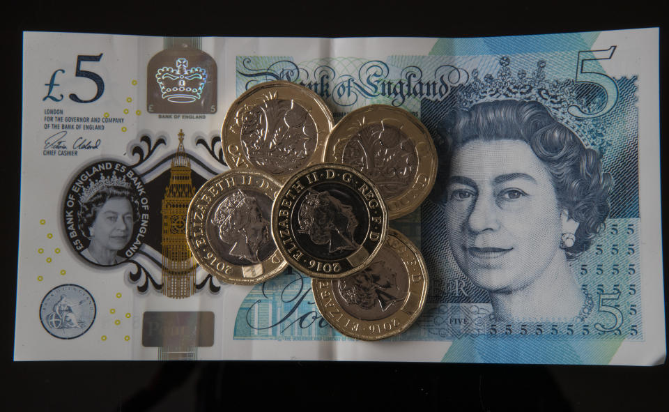 New 12-sided &pound;1 coins on a new &pound;5 note in Liverpool as the new pound coin entered circulation - with early teething problems expected at coin-operated machines across the country.