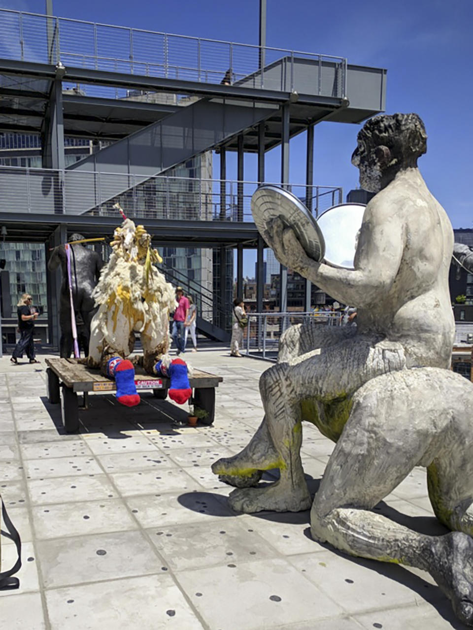 This June 9, 2019 photo shows artwork by Nicole Eisenman, titled "Procession," on a rooftop terrace at the Whitney Museum of American Art. The resignation of museum vice chairman of the board Warren Kanders cam after eight artists, including Eisenman had requested to have their work pulled from the museum in protest to Kanders' ownership of a company that makes law enforcement supplies, including tear gas. (David Lutzker via AP)