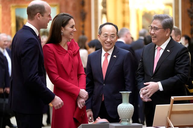<p>Kin Cheung - WPA Pool/Getty</p> Prince William and Kate Middleton chat with Choo Kyungho, Korea's Deputy Prime Minister, second right and Park Jin, the Korean Minister of Foreign Affairs, right, at Buckingham Palace on November 21.
