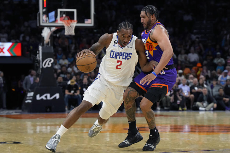 LA Clippers forward Kawhi Leonard (2) drives on Phoenix Suns forward Ish Wainright during the second half of an NBA basketball game, Sunday, April 9, 2023, in Phoenix. The Clippers won 119-114. (AP Photo/Rick Scuteri)