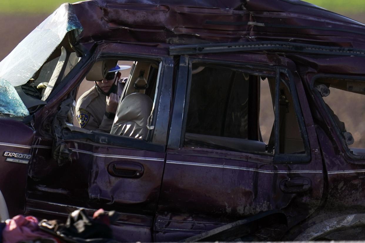 A California Highway Patrol officer examines the scene of a deadly crash in Holtville, Calif., Tuesday, March 2, 2021. 