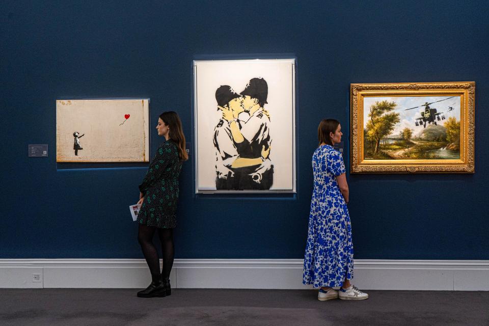 LONDON, UK. 21st Feb, 2022. (L to R) BANKSY, Girl With Balloon, 2006, Kissing Coppers, 2005;Vandalised Oil (Choppers), 2006. The three paintings owned by ROBBIE WILLIAMS ahead of a sale of Modern and Contemporary Art, at Sotheby's auction house. Credit: amer ghazzal/Alamy Live News