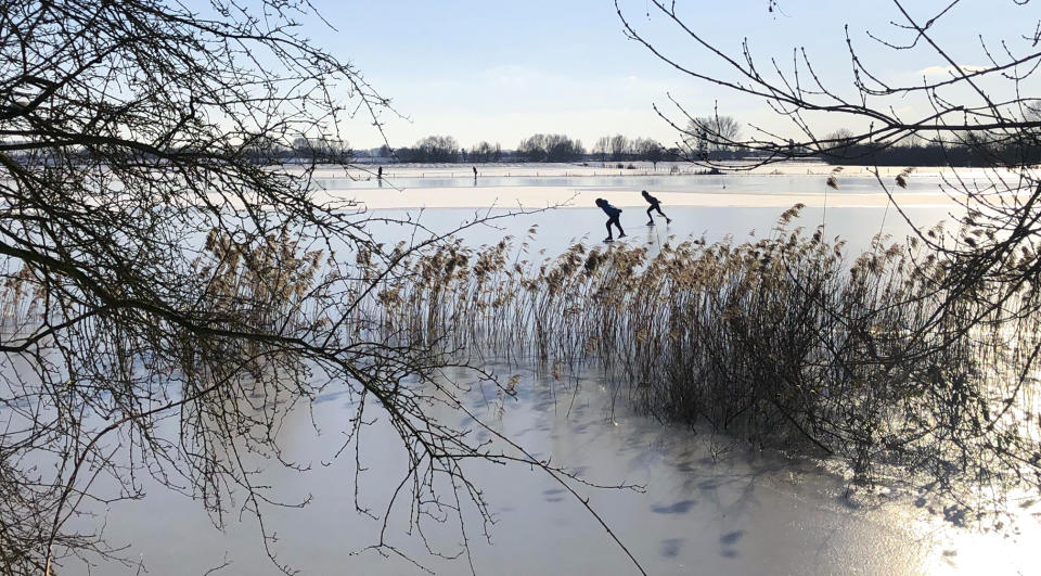 People skate on Nederrijn river near Doorwerth, Netherlands, Thursday, Feb. 11, 2021. The deep freeze gripping parts of Europe served up fun and frustration with heavy snow cutting power to some 37,000 homes in central Slovakia. (AP Photo/Aleksandar Furtula)