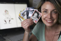 In this April 30, 2020, photo, Anika Orrock holds some of her autographed baseball cards of players from the All-American Girls Baseball League at her home in Nashville, Tenn. Orrock has written and illustrated a book on the players titled "The Incredible Women of the All-American Girls Professional Baseball League." (AP Photo/Mark Humphrey)