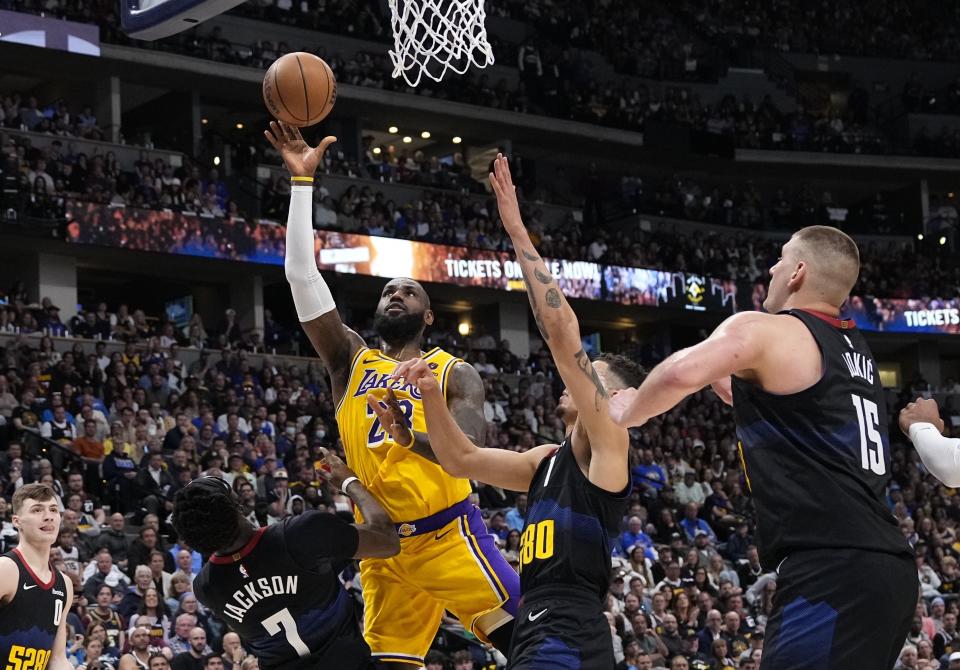 Los Angeles Lakers forward LeBron James (23) goes up for a shot against Denver Nuggets guard Reggie Jackson (7) and center Nikola Jokic (15) during the second half in Game 2 of an NBA basketball first-round playoff series Monday, April 22, 2024, in Denver. (AP Photo/Jack Dempsey)