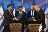 Israeli Prime Minister Naftali Bennett, second right, and Honduran President Juan Orlando Hernandez, second left, look on as Israeli Foreign Minister Yair Lapid, right, and Honduran Foreign Minister Lisandro Rosales exchange signed agreements between their two countries at the prime minister's office, in Jerusalem, Thursday, June 24, 2021. (Heidi Levine/Pool via AP).