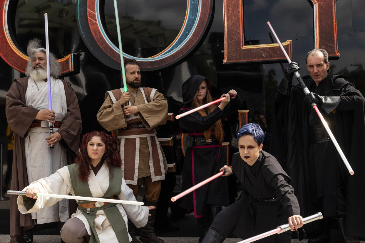 Six people dressed as Star Wars characters brandish lightsabers in Milan.