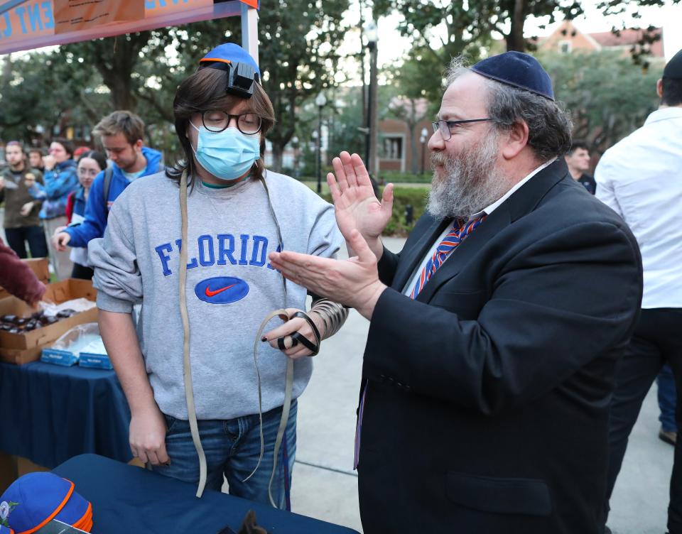 Rabbi Berl Goldman, Chabad UF Jewish Student Center, prays with UF student Jacob Giner during an event to celebrate the second night of Hanukkah at the Plaza of the Americas on the University of Florida campus.