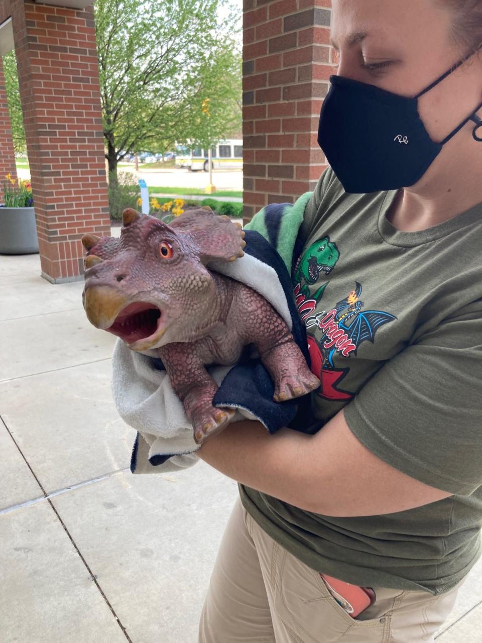 An animatronic baby triceratops is carried by its puppeteer into HSHS St. Vincent Children's Hospital. The little creature was a hit for the younger patients.