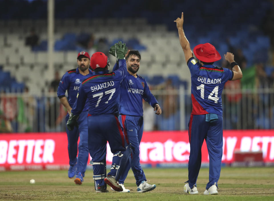 Afghanistan's Rashid Khan, center, celebrates the dismissal of Scotland's Michael Leask during the Cricket Twenty20 World Cup match between Afghanistan and Scotland in Sharjah, UAE, Monday, Oct. 25, 2021. (AP Photo/Aijaz Rahi)