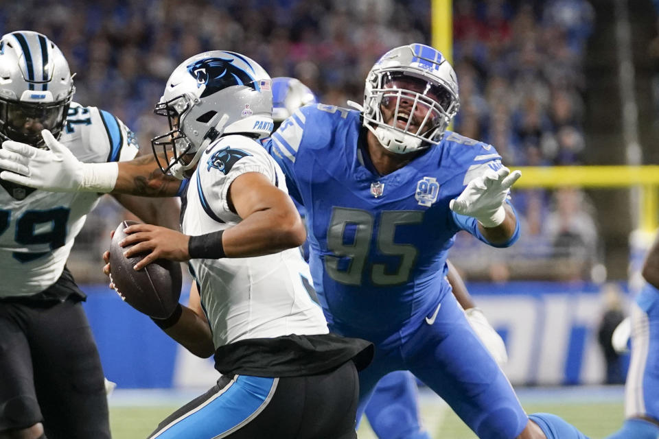 Carolina Panthers quarterback Bryce Young (9) scrambles under pressure from Detroit Lions defensive end Romeo Okwara (95) in the first half of an NFL football game in Detroit, Sunday, Oct. 8, 2023. (AP Photo/Paul Sancya)