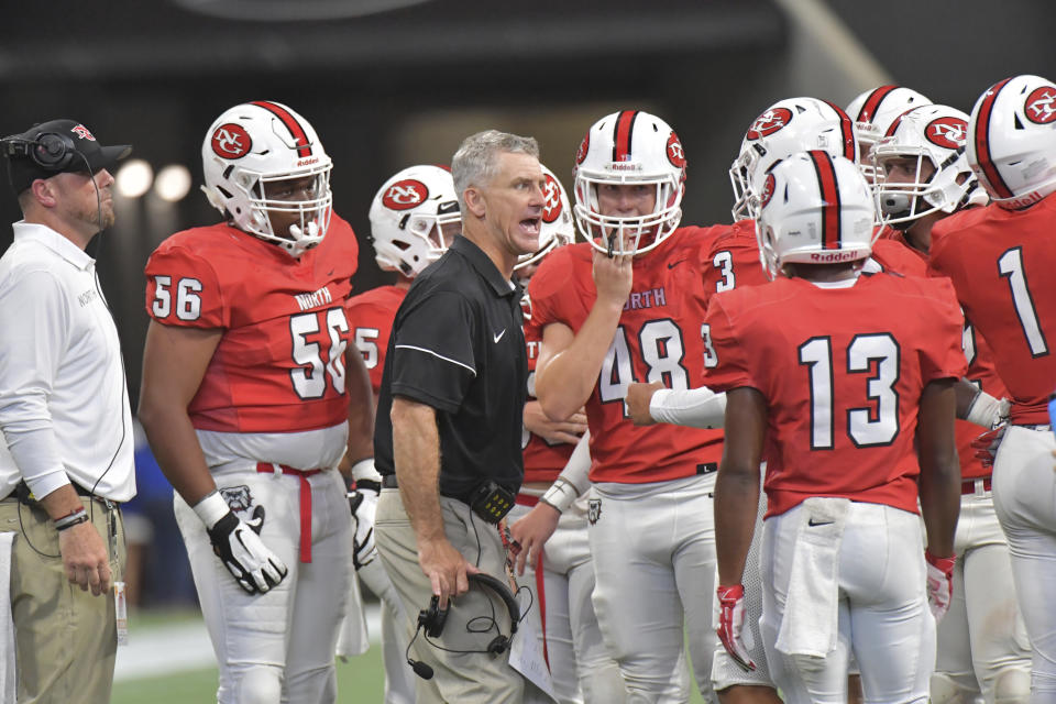 In this Aug. 24, 2019 photo, North Gwinnett head coach Bill Stewart instructs his team in the second half of the Corky Kell Classic high school football game against Colquitt County at Mercedes-Benz Stadium in Atlanta. Georgia has become the clear No. 4 state behind Texas, Florida and California for producing major college football players. (Hyosub Shin/Atlanta Journal-Constitution via AP)