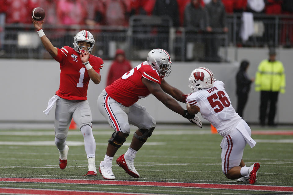 Ohio State quarterback Justin Fields, left, throws a pass as offensive lineman Thayer Munford, center, blocks Wisconsin linebacker Zack Baun during the first half of an NCAA college football game Saturday, Oct. 26, 2019, in Columbus, Ohio. (AP Photo/Jay LaPrete)