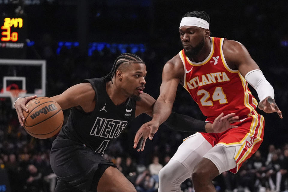 Atlanta Hawks' Bruno Fernando (24) defends against Brooklyn Nets' Dennis Smith Jr. (4) during the second half of an NBA basketball game Thursday, Feb. 29, 2024, in New York. (AP Photo/Frank Franklin II)