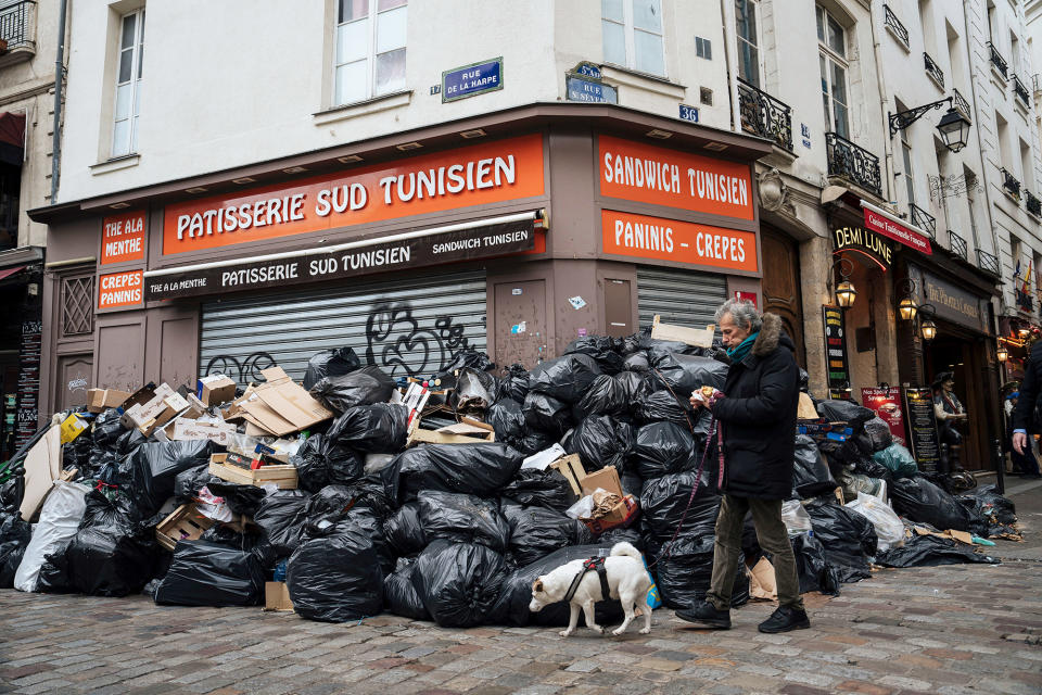 A man walks past piles of garbage in Paris, on March 13, 2023. 