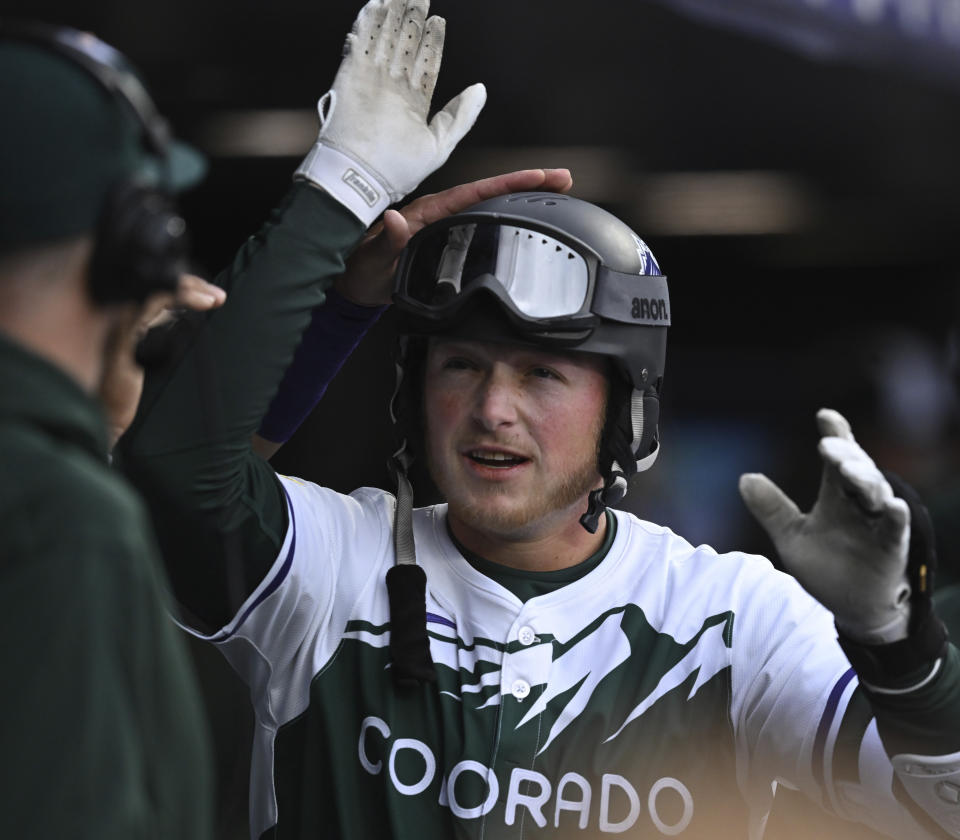 Colorado Rockies' Hunter Goodman is congratulated in the dugout after hitting a home run in the third inning of a baseball game against the Texas Rangers, Saturday, May 11, 2024, in Denver. (AP Photo/Jerilee Bennett)