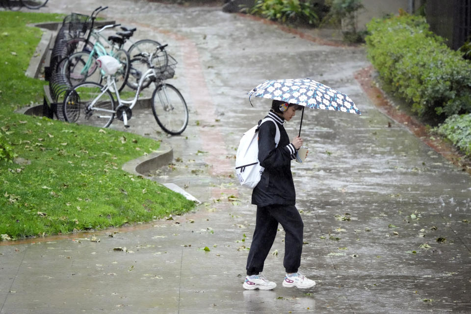 A pedestrian covers herself with an umbrella on the University of Southern California campus Tuesday, March 21, 2023, in Los Angeles. (AP Photo/Marcio Jose Sanchez)