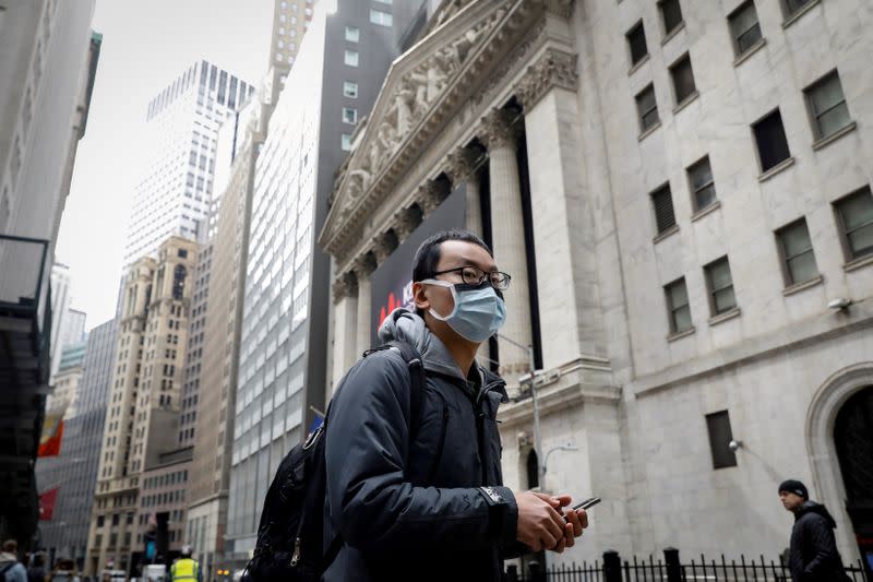 FILE PHOTO: A man wears a mask on Wall St. near the NYSE in New York