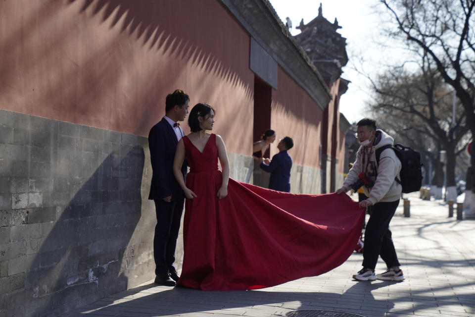 Couples have their wedding photos taken near the Forbidden City area in Beijing on Sunday, Dec. 20, 2020. Lovebirds in China are embracing a sense of normalcy as the COVID pandemic appears to be under control in the country where it was first detected. (AP Photo/Ng Han Guan)