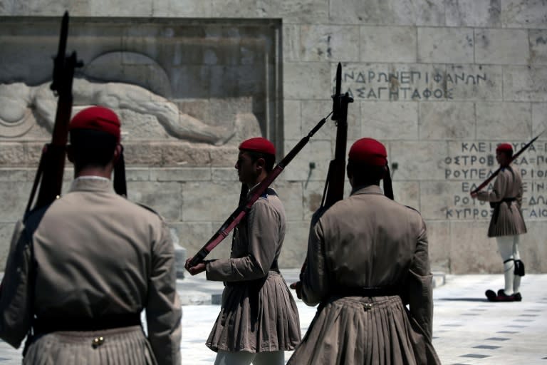 Greek "Evzones" presidential guards stand at attention in front of the Greek parliament in Athens on July 6, 2015