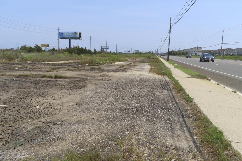 FILE - A car drives past a vacant lot, Wednesday, July 27, 2023, in Egg Harbor Township, N.J., where a string of seedy motels used to stand. The discovery of four dead women in a drainage ditch behind the motels just outside Atlantic City was shocking news in 2006. But as the years passed, the public’s attention and fear faded, and the case of the “Eastbound Strangler” – so named for the direction the victims’ heads were facing – remained unsolved. (AP Photo/Wayne Parry, File)