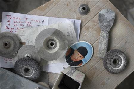 A picture of a male crime victim, printed on ceramic, is seen at a tombstone factory near the Southern Cemetery in Caracas December 8, 2012. REUTERS/Carlos Garcia Rawlins