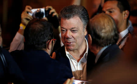 Colombia's President Juan Manuel Santos and Marxist FARC rebel leader Rodrigo Londono, known as Timochenko, shake hands after celebrating a year of peace signing in Bogota, Colombia November 24, 2017. REUTERS/Jaime Saldarriaga
