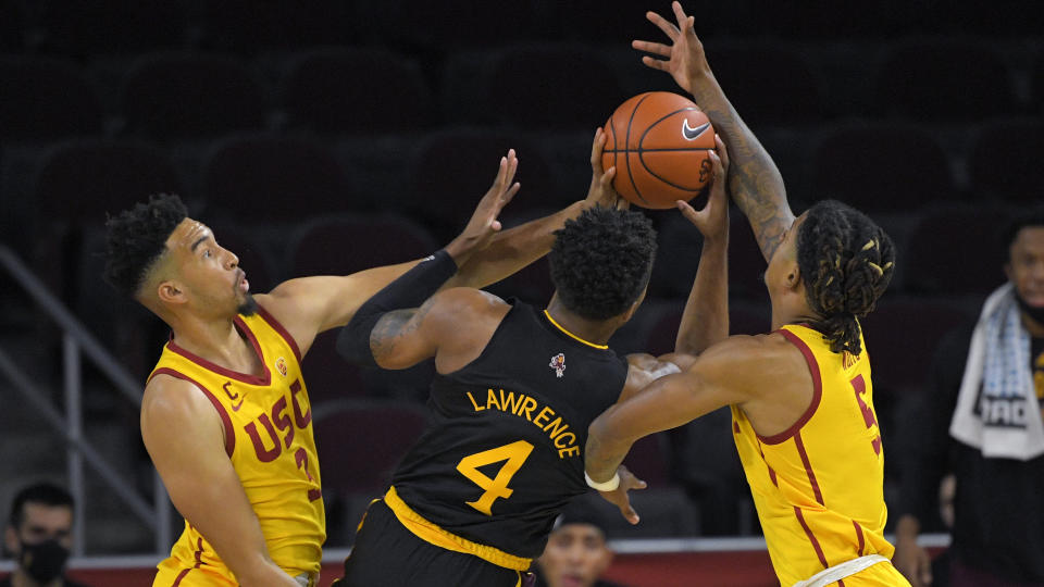Arizona State forward Kimani Lawrence, center, shoots as Southern California forward Isaiah Mobley, left, and guard Isaiah White defend during the first half of an NCAA college basketball game Wednesday, Feb. 17, 2021, in Los Angeles. (AP Photo/Mark J. Terrill)