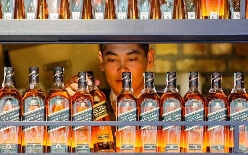 A bartender takes a bottle of Johnnie Walker whisky in Almaty, Kazakhstan - REUTERS