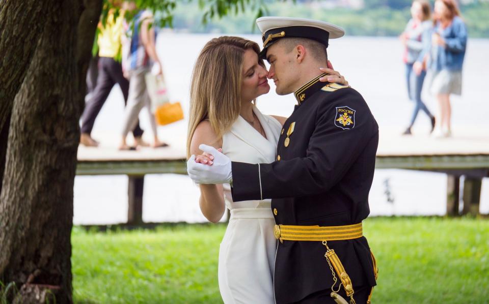 An officer, military graduate, dances with a young woman in a park in Voronezh, Russia on Sunday