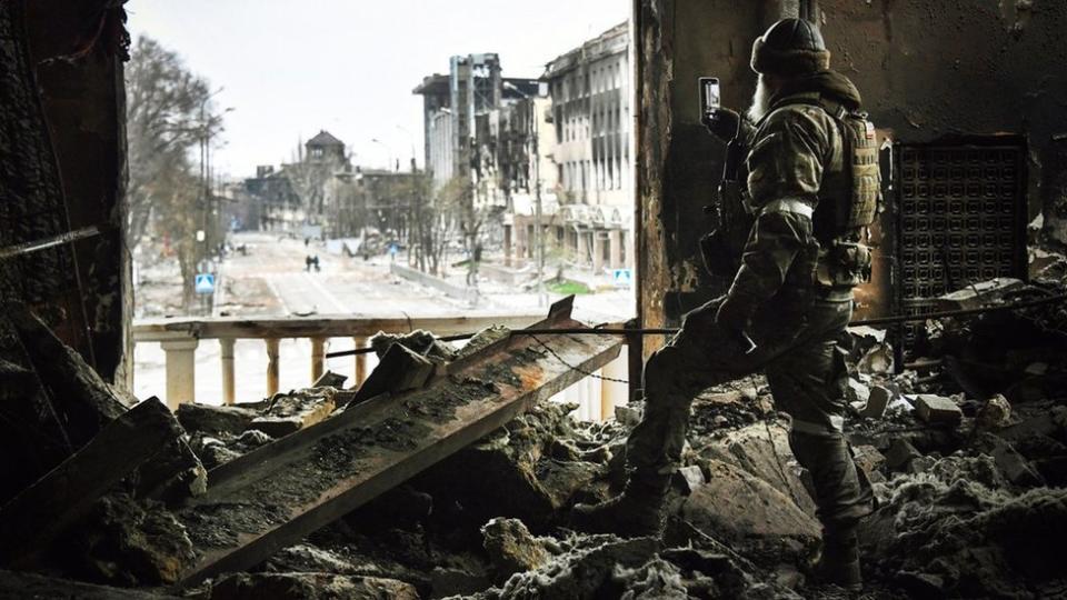 Un hombre toma una foto desde el teatro destrozado.