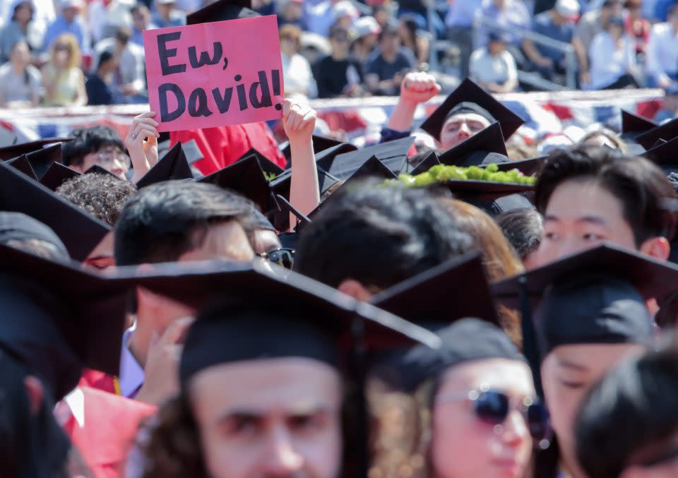 Boston, MA - May 21: A graduating student holds up a sign while key notes speaker Davis Zaslav (chief executive officer and president of Warner Bros. Discovery) speaks during Boston University's 150th graduation ceremony at Nickerson Field. (Photo by Matthew J. Lee/The Boston Globe via Getty Images)